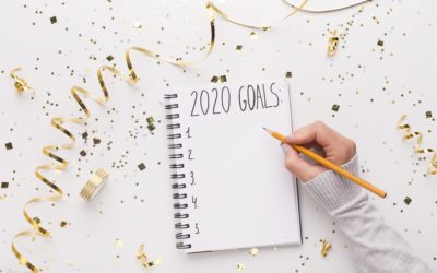 Woman writing down in notepad with 2020 goals