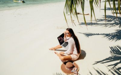 Remote working woman on beach in tropics