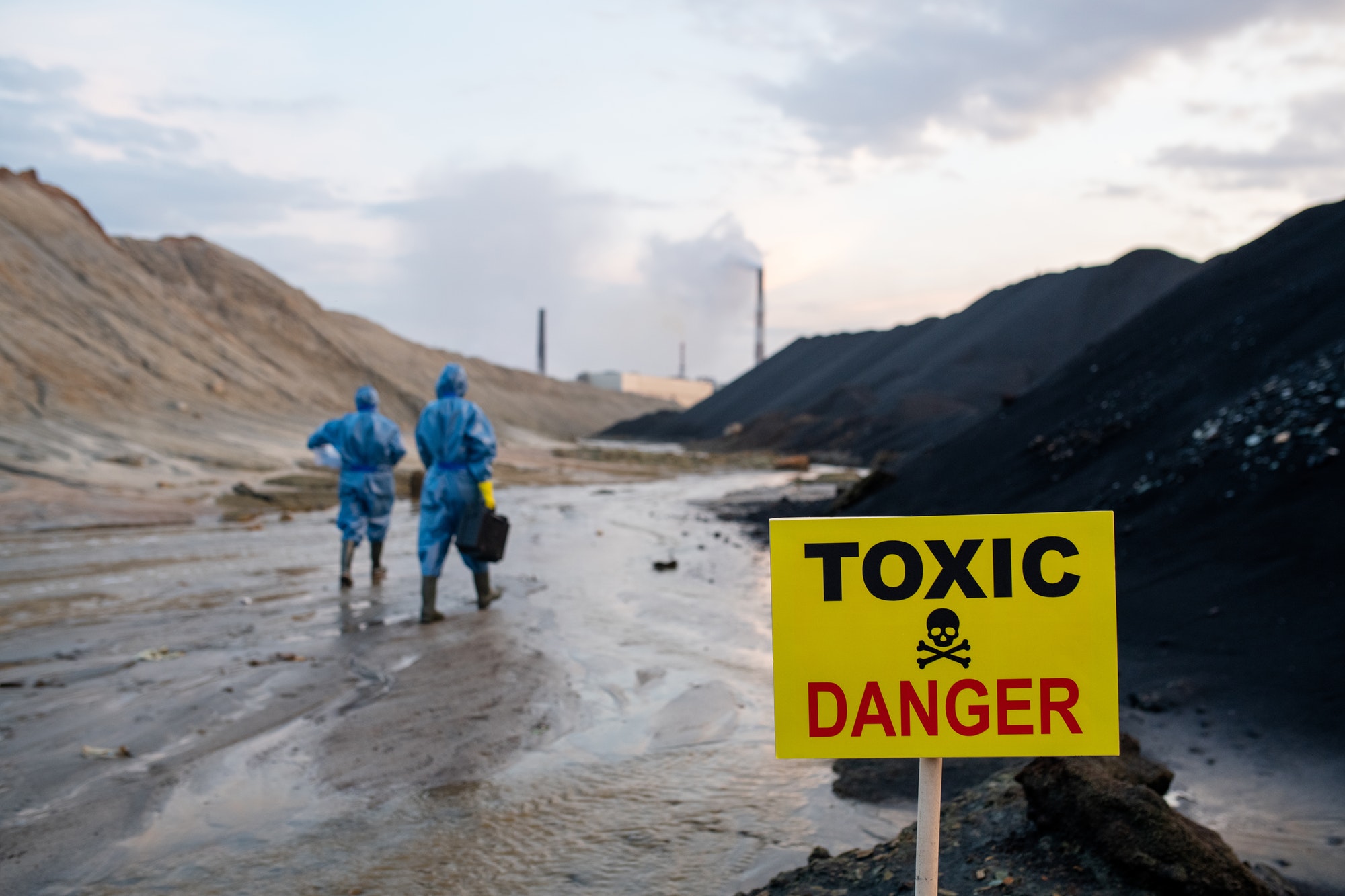 Announcement about toxic and dangerous area on background of ecologists