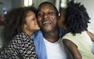 African children kissing their father