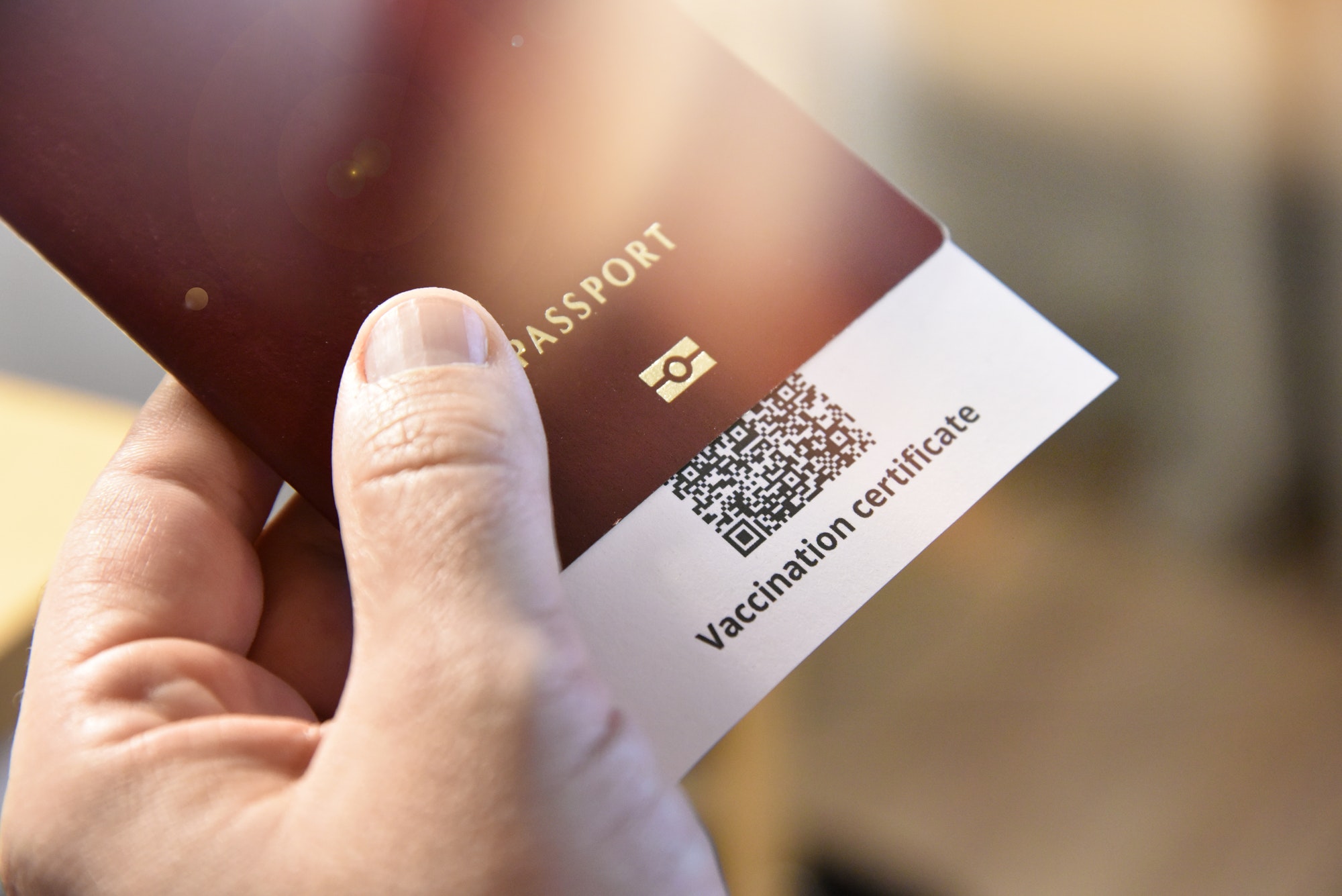 Man's Hand Holding Passport and Certificate of Vaccination Against Covid-19