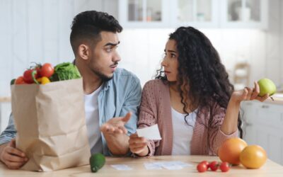 Prices Increase. Frustrated Young Arab Spouses Looking At Bills After Grocery Shopping