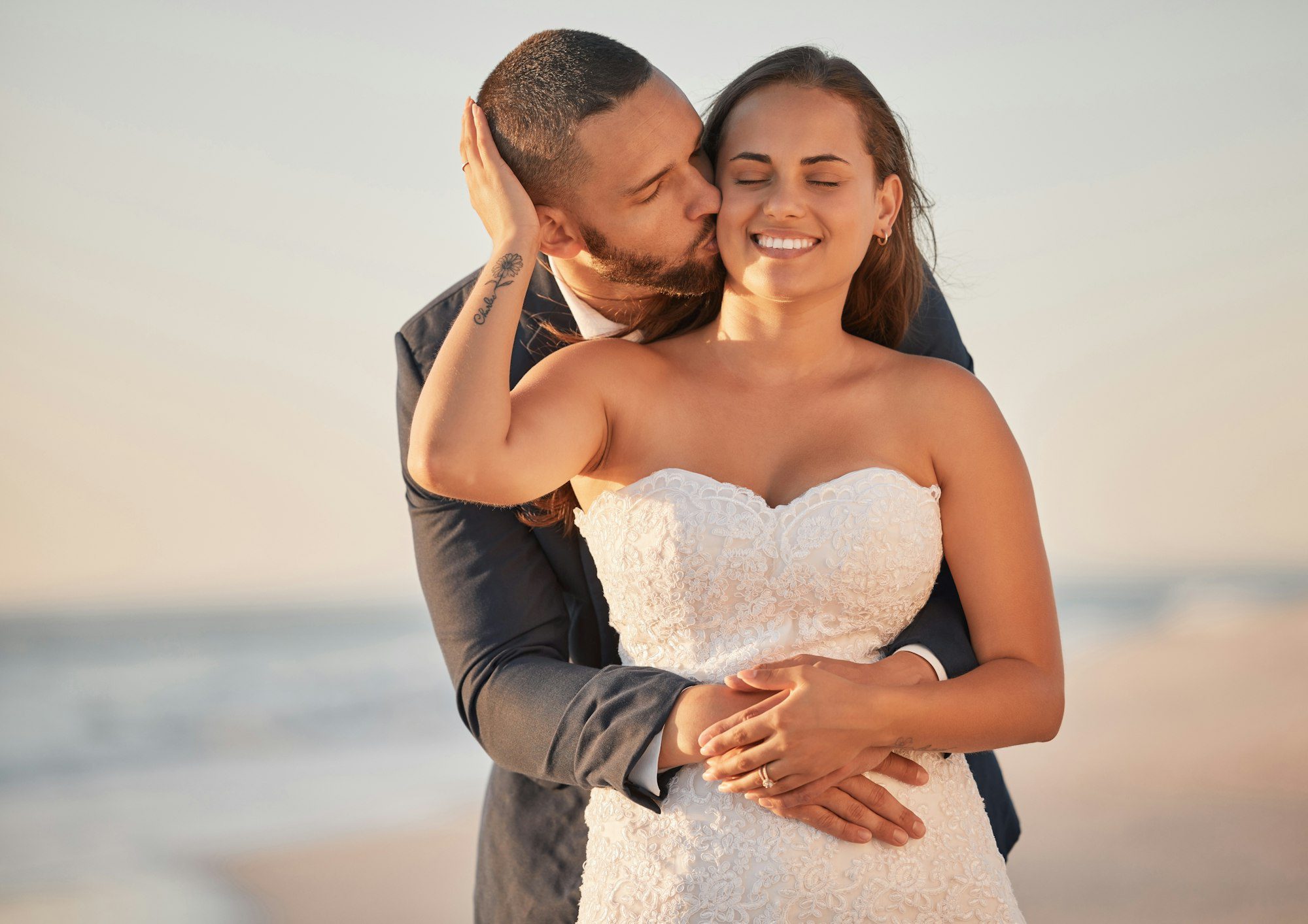 Wedding kiss, beach reception and couple in celebration of marriage at the ocean and bride and groo