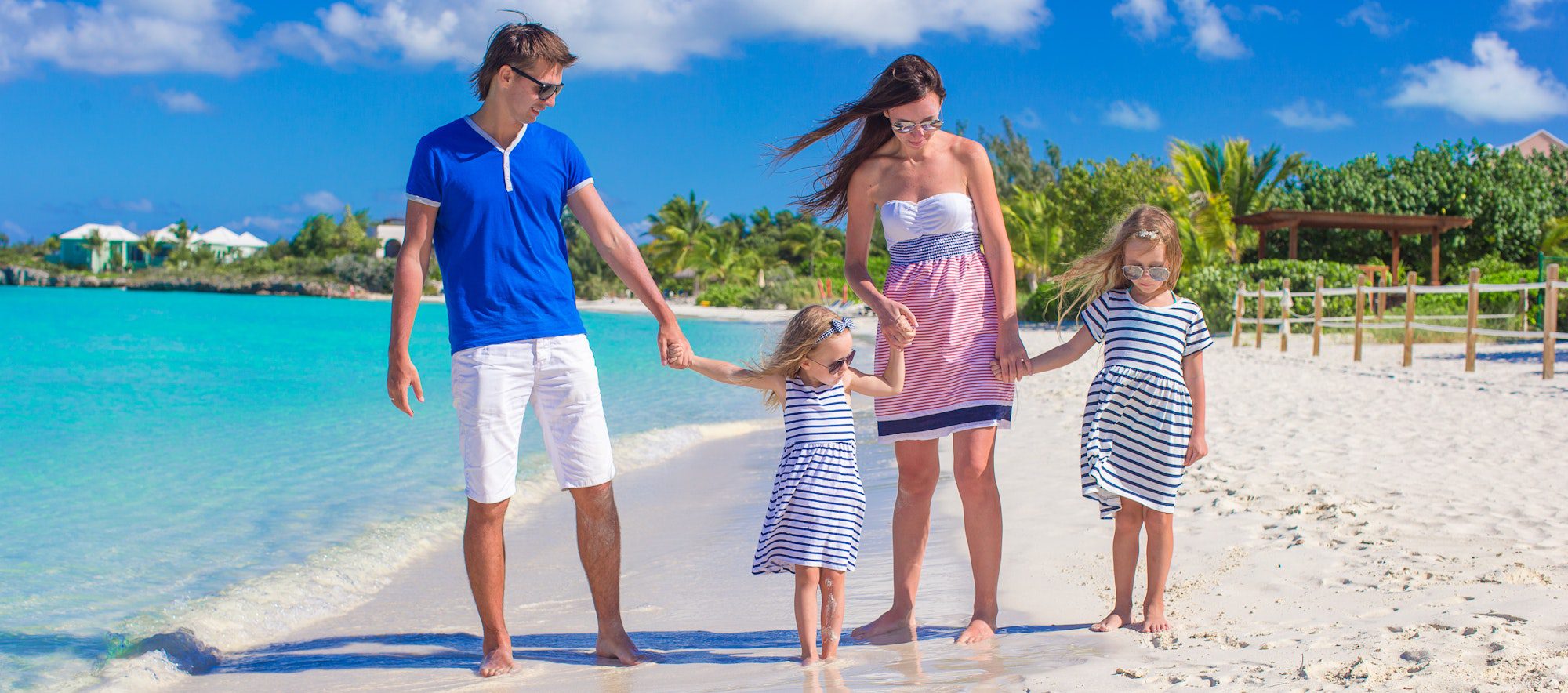 Young family with two kids at tropical white beach