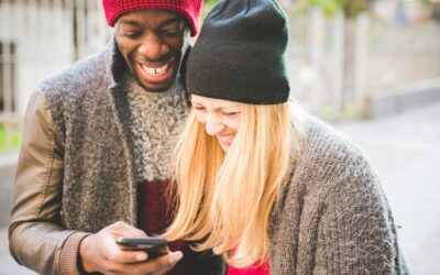 Couple smiling at message on smartphone