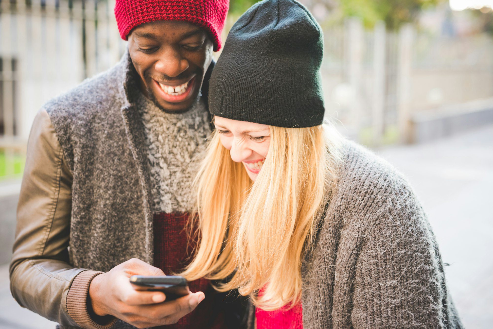 Couple smiling at message on smartphone