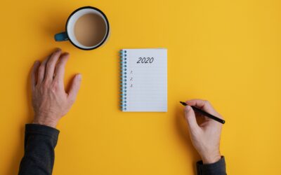 Top view of a man writing down plans or resolutions for the year 2020