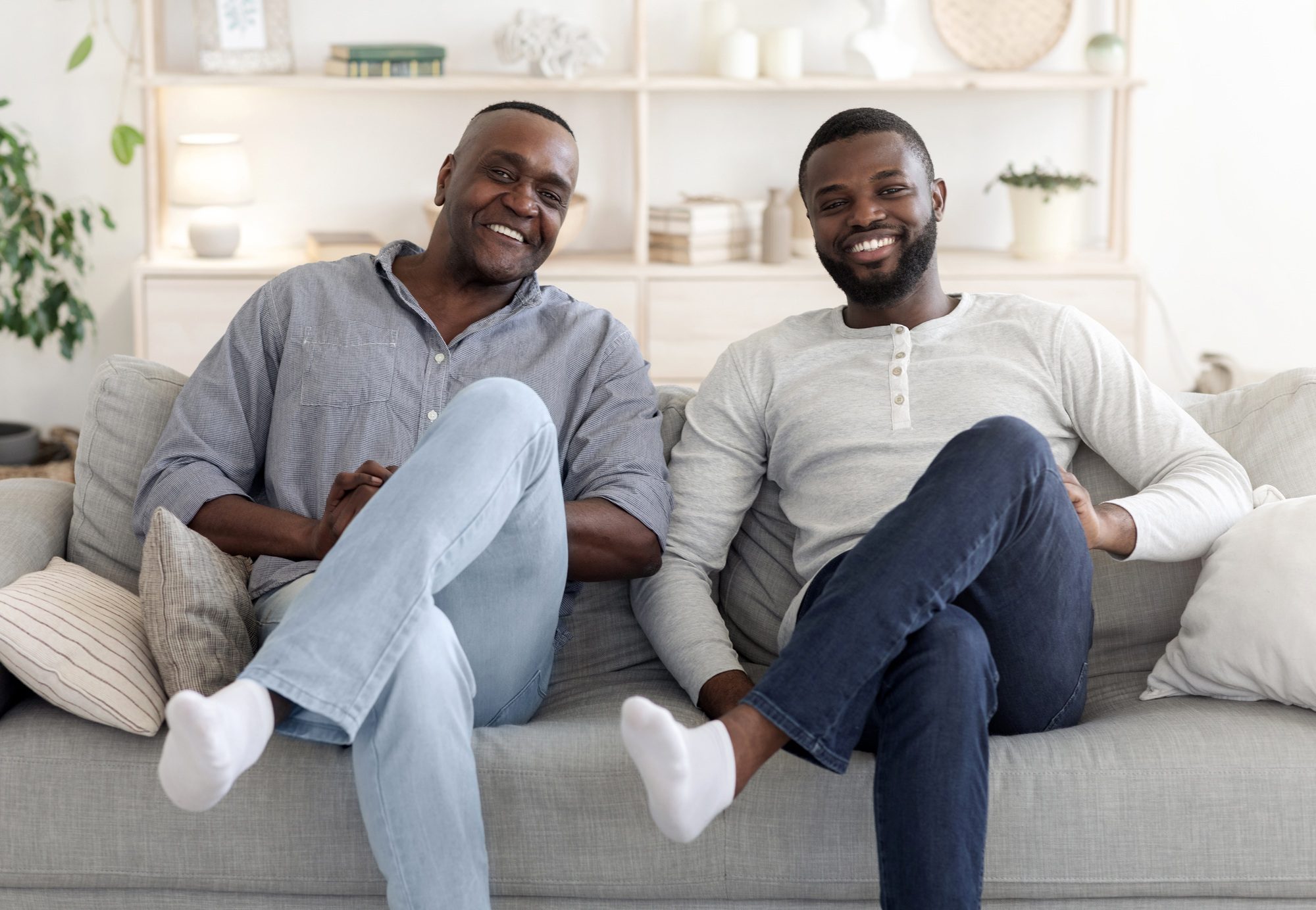 Like Father Like Son. Happy Man Sitting In Similar Pose With Dad