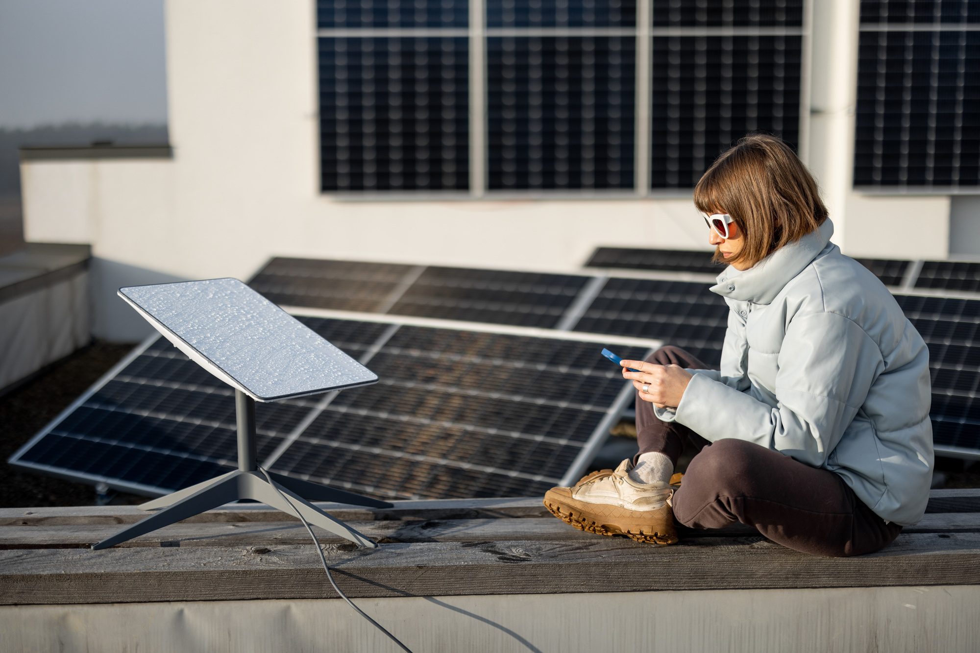 Woman uses Starlink Internet on roof with solar panels