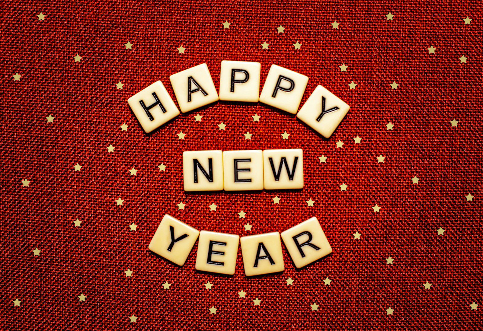 happy new year spelled with scrabbles on a red background
