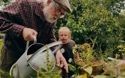 a man and a child looking at a plant