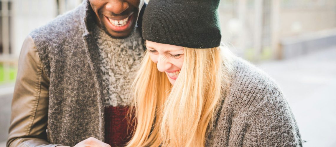 Couple smiling at message on smartphone